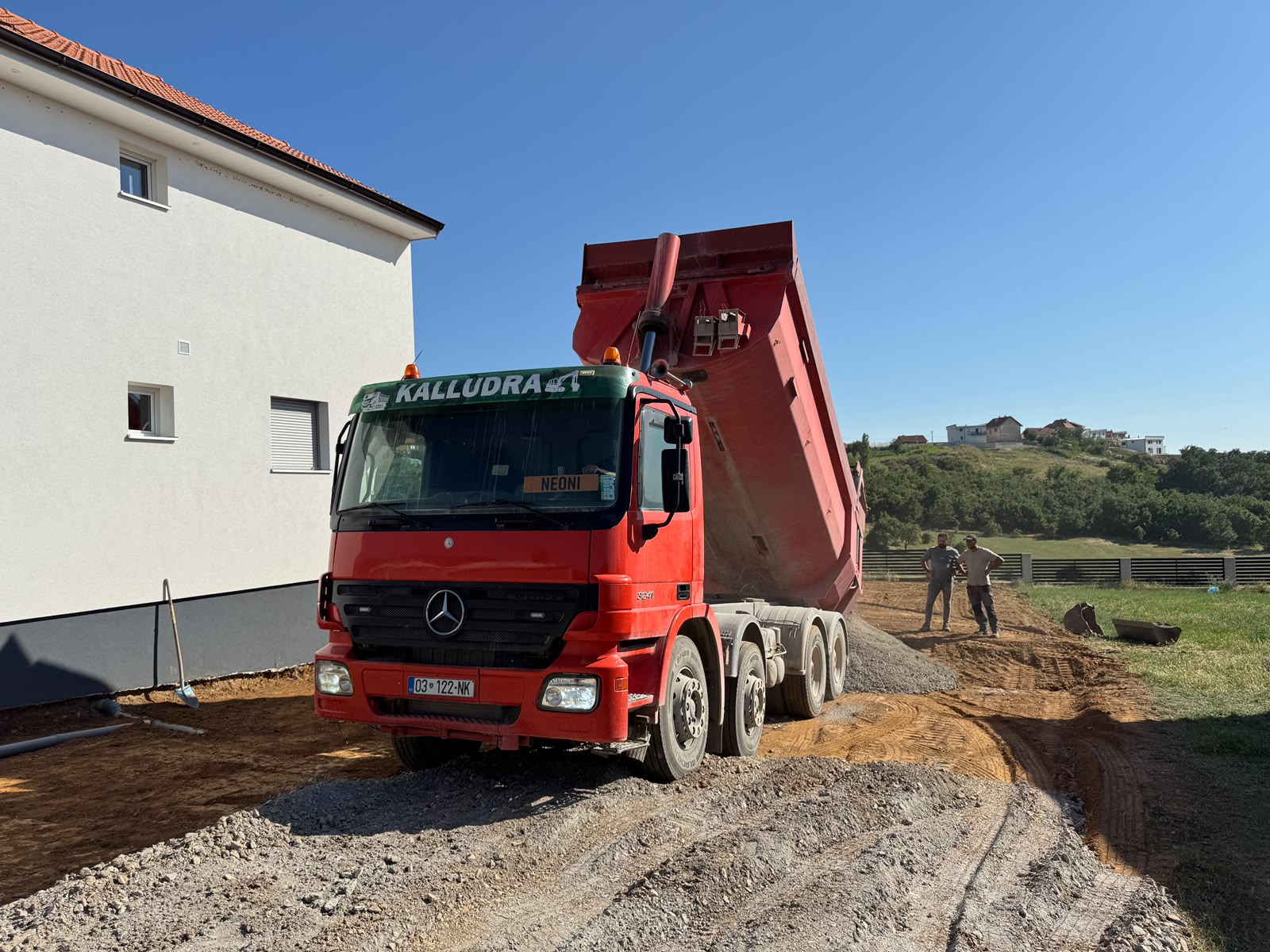 Kamioni i Kalludra Group duke derdhur zhavorr në oborrin e një shtëpie në ndërtim